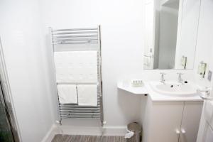 een witte badkamer met een wastafel en een spiegel bij Smithfield Guesthouse in Dounby