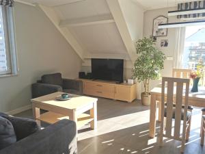 ein Wohnzimmer mit Fernseher und Tisch in der Unterkunft Apartamenty Wybrzeże Laguna II in Ustronie Morskie