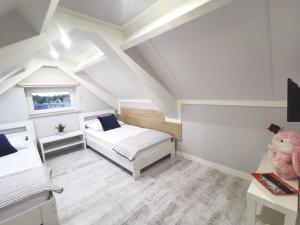 ein Schlafzimmer im Dachgeschoss mit einem Bett und einem Teddybär in der Unterkunft Apartamenty Wybrzeże Laguna II in Ustronie Morskie