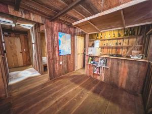 a room with wooden walls and a kitchen with wooden floors at Alojamiento frente al mar playa la barra in Buenaventura