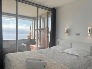 a bedroom with a large bed with a large window at SARA RIVIERA Costa Plana in Cap d'Ail