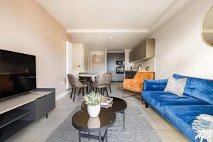 a living room with a blue couch and a table at Charles Hope Leeds in Leeds