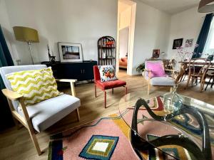 a living room with chairs and a table at Le Quai de la Deûle in Lambersart