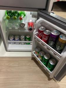 - un réfrigérateur ouvert rempli de boissons et de canettes sans alcool dans l'établissement Shamish Relaxing Getaway Studio, à Manille