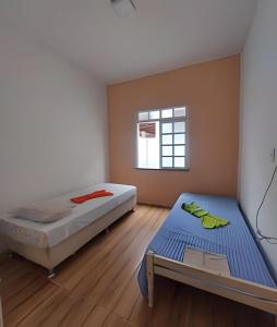 Casa Ilha de Itaparica Aratuba في Aratuba Beach: غرفة نوم بها سريرين ونافذة