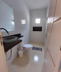 Casa Ilha de Itaparica Aratuba في Aratuba Beach: حمام أبيض مع حوض ومرحاض