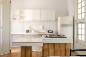 una cucina bianca con armadi bianchi e frigorifero di Casa Ilha de Itaparica Aratuba 2 ad Aratuba Beach Altre 17 foto
