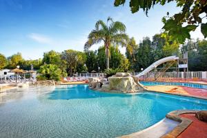 une grande piscine avec un toboggan aquatique dans l'établissement Camping International, à Calvi