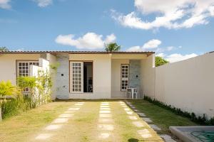 una casa bianca con una recinzione davanti di Casa Ilha de Itaparica Aratuba 2 ad Aratuba Beach
