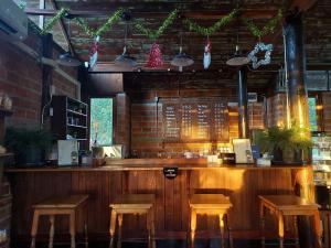 a bar with stools in a restaurant with christmas decorations at Why Worry Homestay & Café in Ban Talat Khwai +56 photos