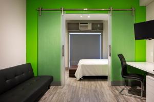a room with green walls and a bed and a couch at Micro Boutique Living Wolfville in Wolfville
