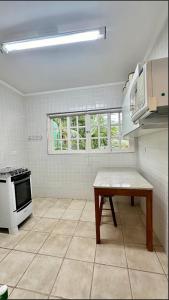 una cucina con piano cottura e tavolo di Apartamento Canto Sul - pé na areia a São Sebastião