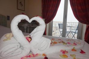two swans made out of towels on a bed at Hotel Splendid in Cannes