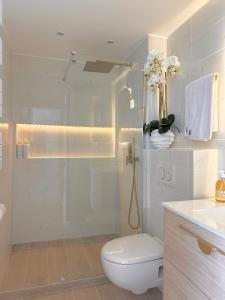 a white bathroom with a toilet and a shower at SARA RIVIERA Costa Plana in Cap d'Ail