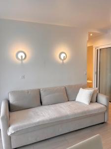 a couch in a living room with two lights at SARA RIVIERA Costa Plana in Cap d'Ail