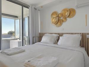a bedroom with a large white bed with fans on the wall at SARA RIVIERA Costa Plana in Cap d'Ail