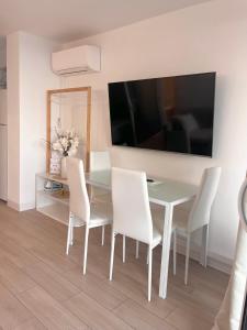a dining room with a white table and white chairs at SARA RIVIERA Costa Plana in Cap d'Ail