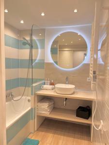 a bathroom with a sink and a tub and a mirror at SARA RIVIERA Costa Plana in Cap d'Ail