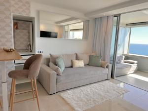 a living room with a couch and a view of the ocean at SARA RIVIERA Costa Plana in Cap d'Ail