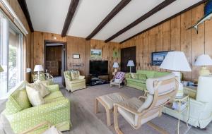 a living room with two couches and a tv at Beachfront cottage on North Shore Grand Haven in Spring Lake