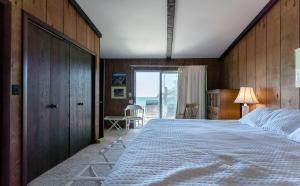 a bedroom with a large bed with a wooden wall at Beachfront cottage on North Shore Grand Haven in Spring Lake