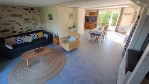 a living room with a blue couch and a table at Gites O Ptit Bonheur - Vendée - 2 Maisons de 85 m2 chacune avec piscine extérieure chauffée & couverte in Saint-Christophe-du-Ligneron