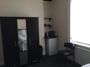 a bedroom with a mirror and a bed with a chair at Hardwick Hotel in Horden