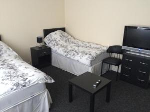 a bedroom with a bed, desk and television at Hardwick Hotel in Horden