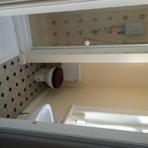 a bathroom with a toilet under a cabinet at Hardwick Hotel in Horden