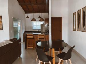 a living room with a table and chairs and a kitchen at Casa Ipoméia Azul in Itacaré