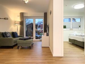 een woonkamer met een bank en een bed bij Herz von Kellenhusen 6 - Moje Koje in Kellenhusen