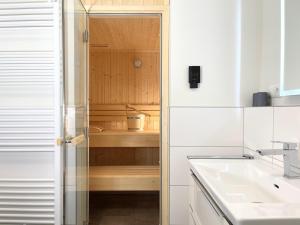 een keuken met een wastafel en een glazen deur bij Herz von Kellenhusen 6 - Moje Koje in Kellenhusen +19 foto's