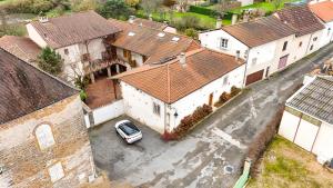een luchtzicht op een huis met een auto op een parkeerplaats bij Gîte Du Pré Pommier - Clim - Piscine - Sauna in Azé