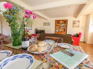 a table with a bottle of wine and a plate of bread at The Old School Cottage in Woodsford