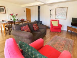 a living room with a couch and two chairs at The Old School Cottage in Woodsford