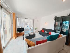 a living room with a couch and a tv at Superbe Appartement Vue mer in Canet-en-Roussillon