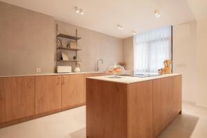 a kitchen with wooden cabinets and a counter top at Stylish & Spacious Flat near the Beach by HostWise in Matosinhos