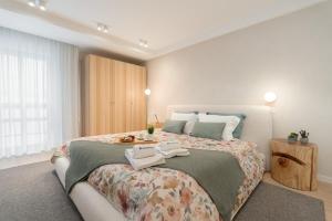 a bedroom with a bed with a tray of food on it at Stylish & Spacious Flat near the Beach by HostWise in Matosinhos