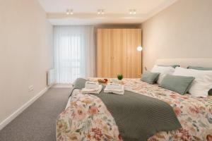 a bedroom with a large bed with two towels on it at Stylish & Spacious Flat near the Beach by HostWise in Matosinhos