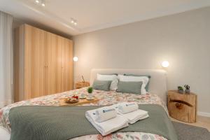 a bedroom with a bed with two towels on it at Stylish & Spacious Flat near the Beach by HostWise in Matosinhos +39 photos