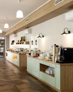 a large kitchen with white cabinets and wooden counters at Ośrodek Wypoczynkowy Świerkocin in Świerkocin