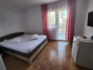 a bedroom with a bed and a large window at Casa Daria in Costinesti