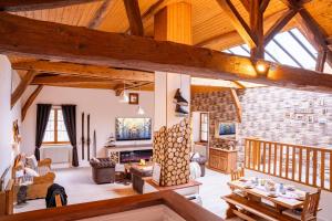 een grote woonkamer met houten plafonds en houten balken bij Gîte Du Pré Pommier - Clim - Piscine - Sauna in Azé