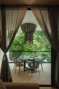 a table and chairs on a patio with a chandelier at Luxury Aldea Zama 2BR Private Pool in Tulum