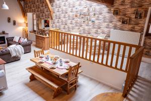 een woonkamer met een houten tafel met kopjes erop bij Gîte Du Pré Pommier - Clim - Piscine - Sauna in Azé