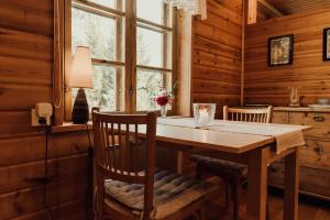 a dining room with a wooden table and chairs at Ireneborg, cottage with Finnish sauna in Svedja +25 photos