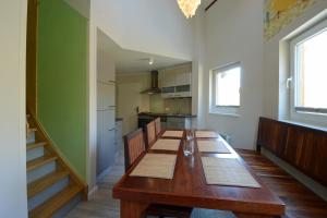 a dining room with a wooden table and a kitchen at Typ C1 Lodge - Napali Coast in Pelzerhaken