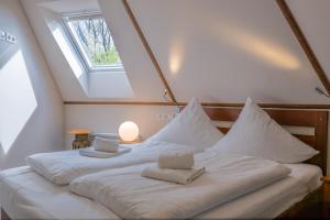 a bedroom with a bed with two towels on it at Typ C1 Lodge - Napali Coast in Pelzerhaken