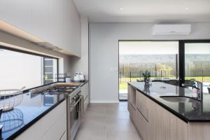 a kitchen with black counter tops and a large window at Luxury Villa 712 Pearl Valley Golf Estate in Paarl