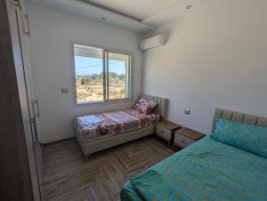 a bedroom with two beds and a window at Kelibia Beach appartments in Kelibia